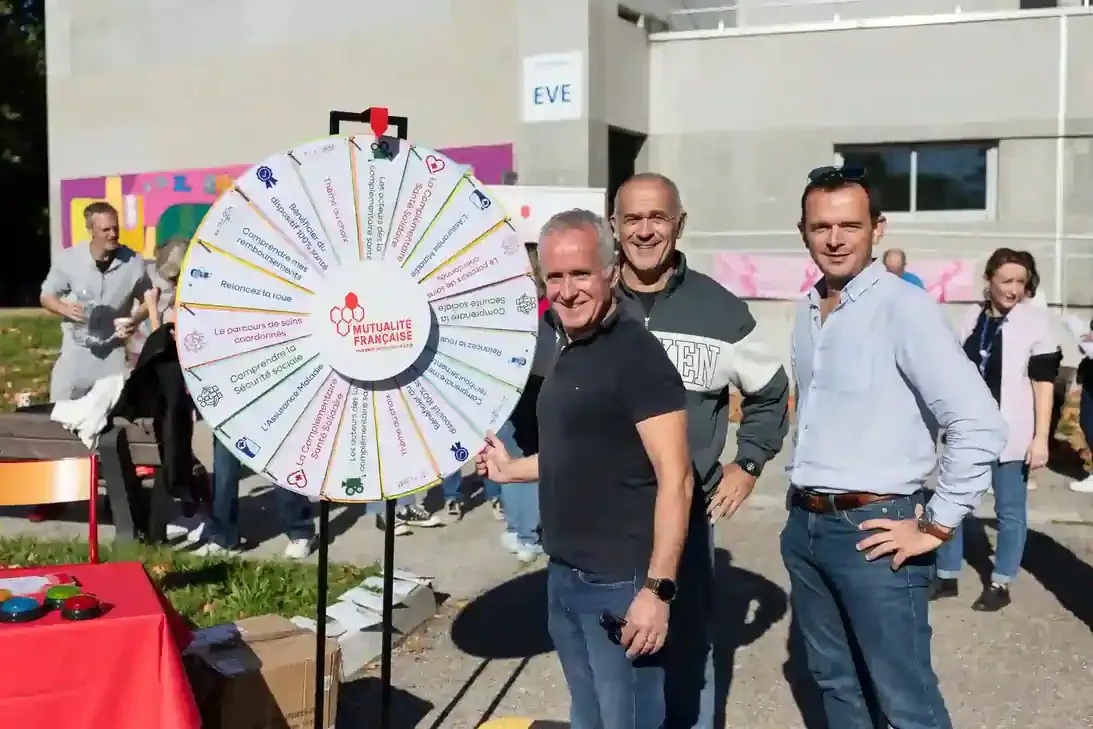 Dominique Viot et des membres de la Mutualité Française Sud devant une roue d'animation sur la santé.